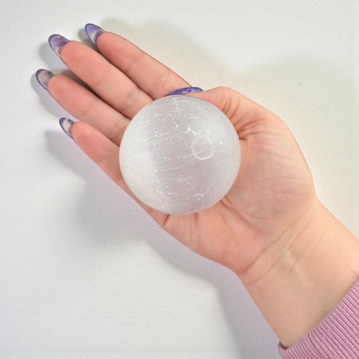 This Selenite Sphere promotes clarity , purity and peace of mind . Use the energy from this crystal sphere to create wholeness throughout the environment and family relationships 