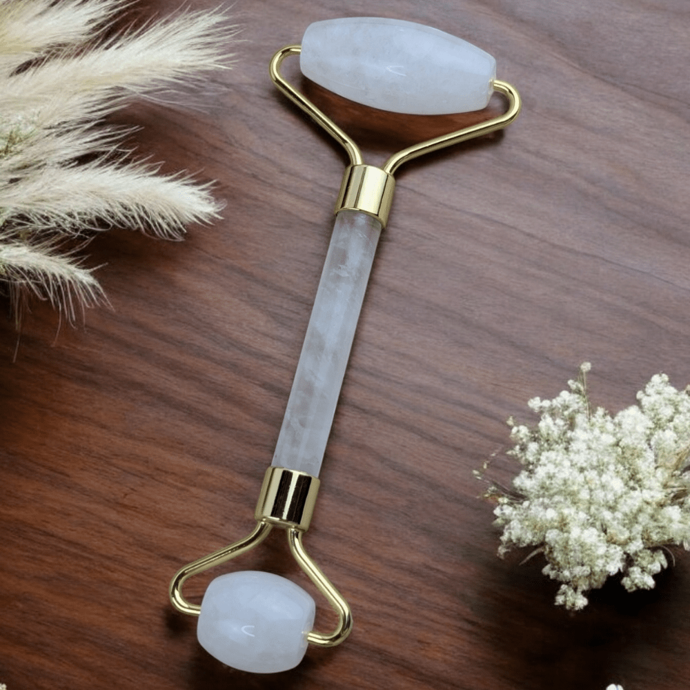 Close-up of clear quartz facial roller with gold accents.