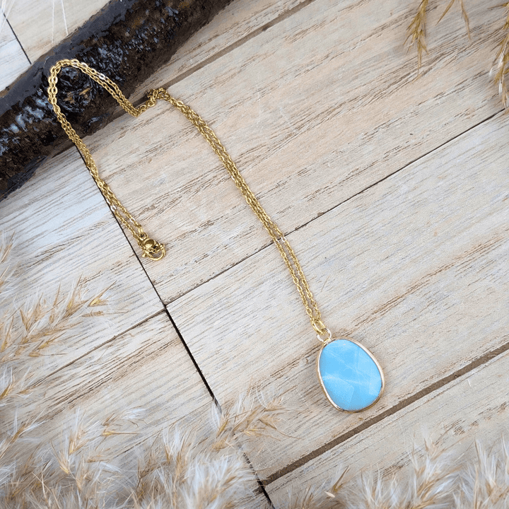 Polished Amazonite stone necklace on a wooden background.