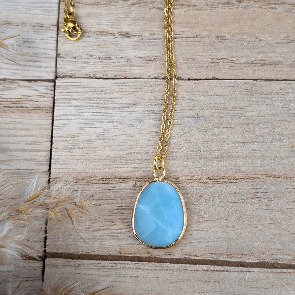 Oval-shaped Amazonite stone set in a gold-tone frame.