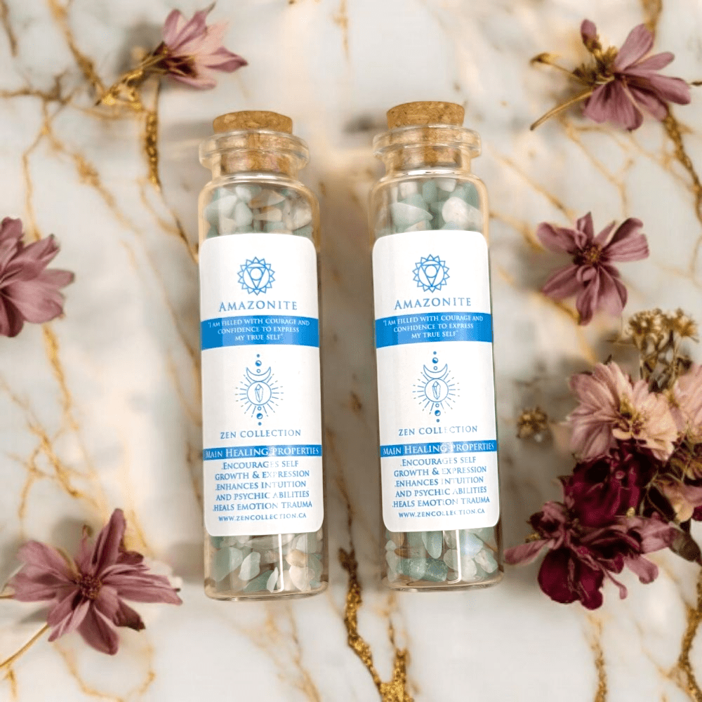 Two Amazonite crystals for throat Zen Collection bottles on a marble surface with flowers.