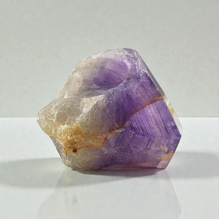 Amethyst Crystal Point with hints of iron on a soft background. picture taken by zen collection spiritual store in barrie