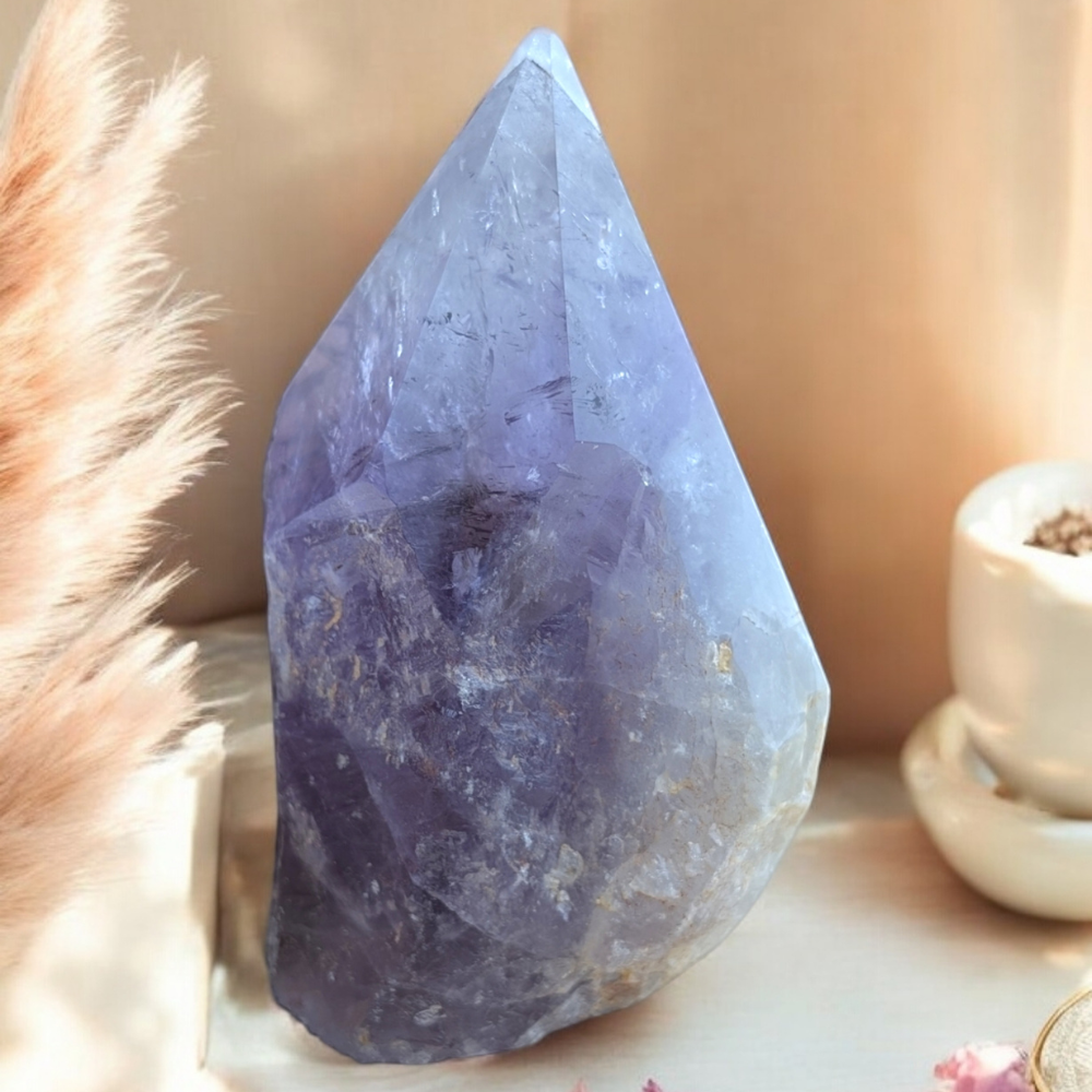 Amethyst Crystal Point on a decorative surface for energy cleansing.