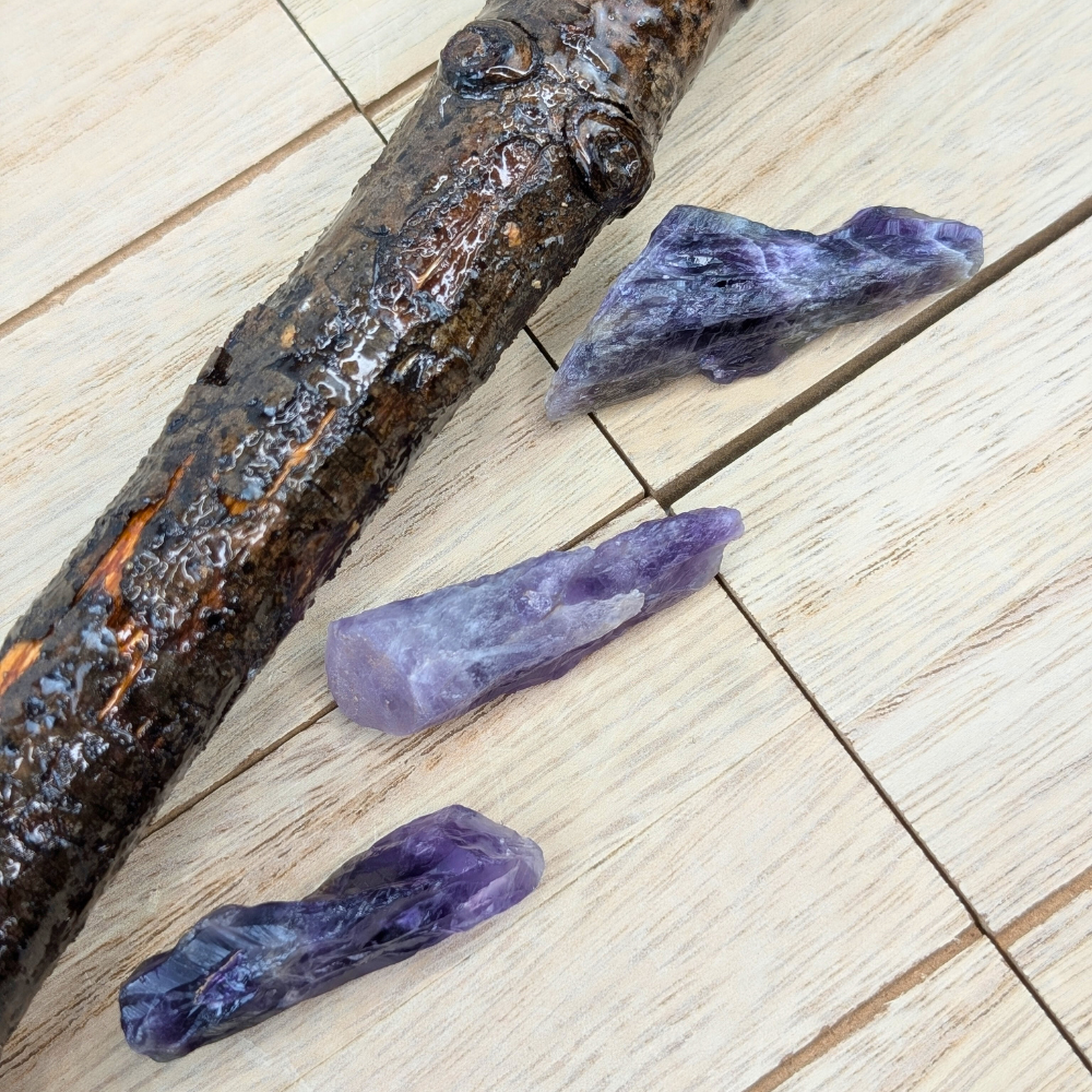 Unpolished Amethyst crystals on a natural wood surface