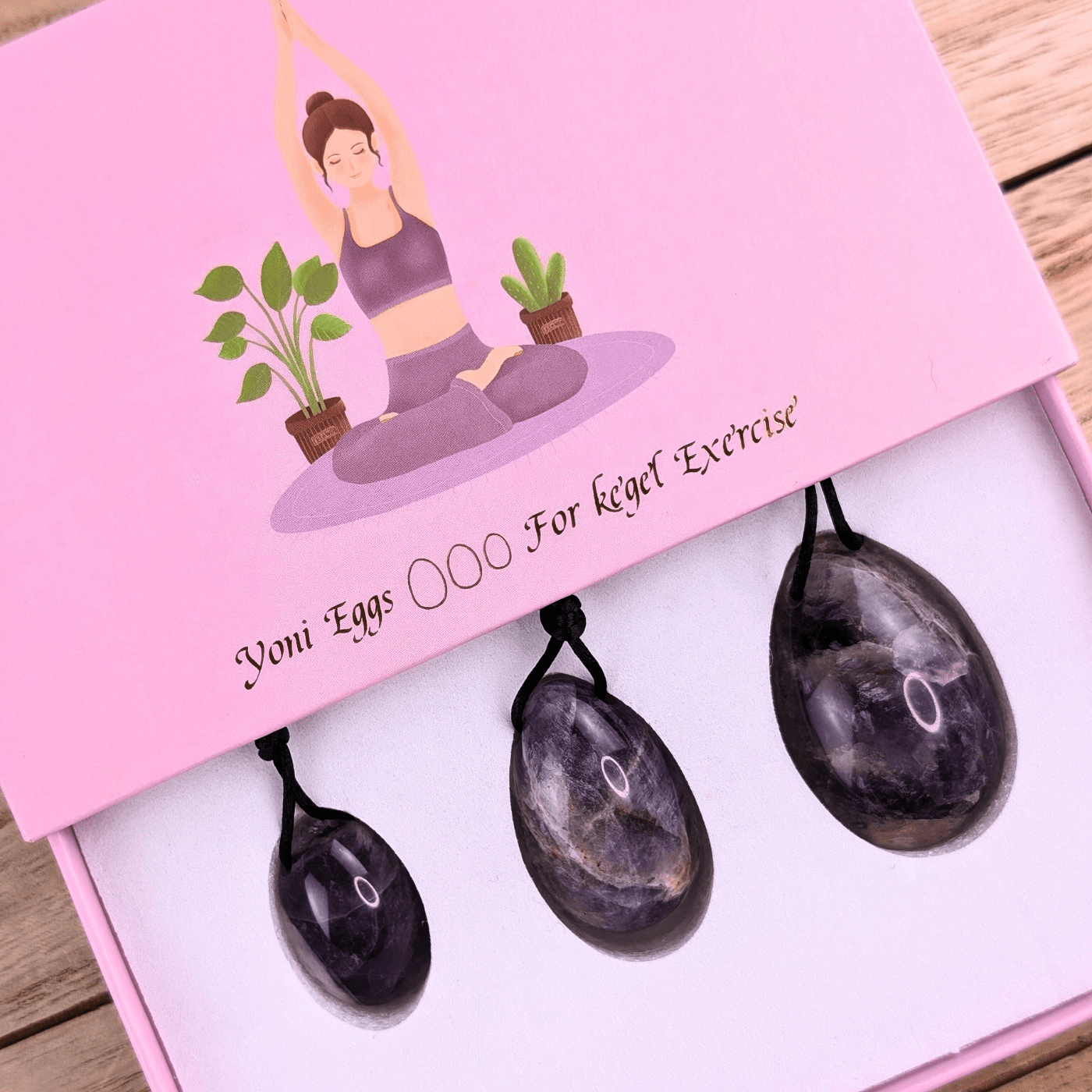 Amethyst Yoni Egg Set Display - Shows the set of three amethyst yoni eggs in different sizes, highlighting their smooth, polished surfaces.