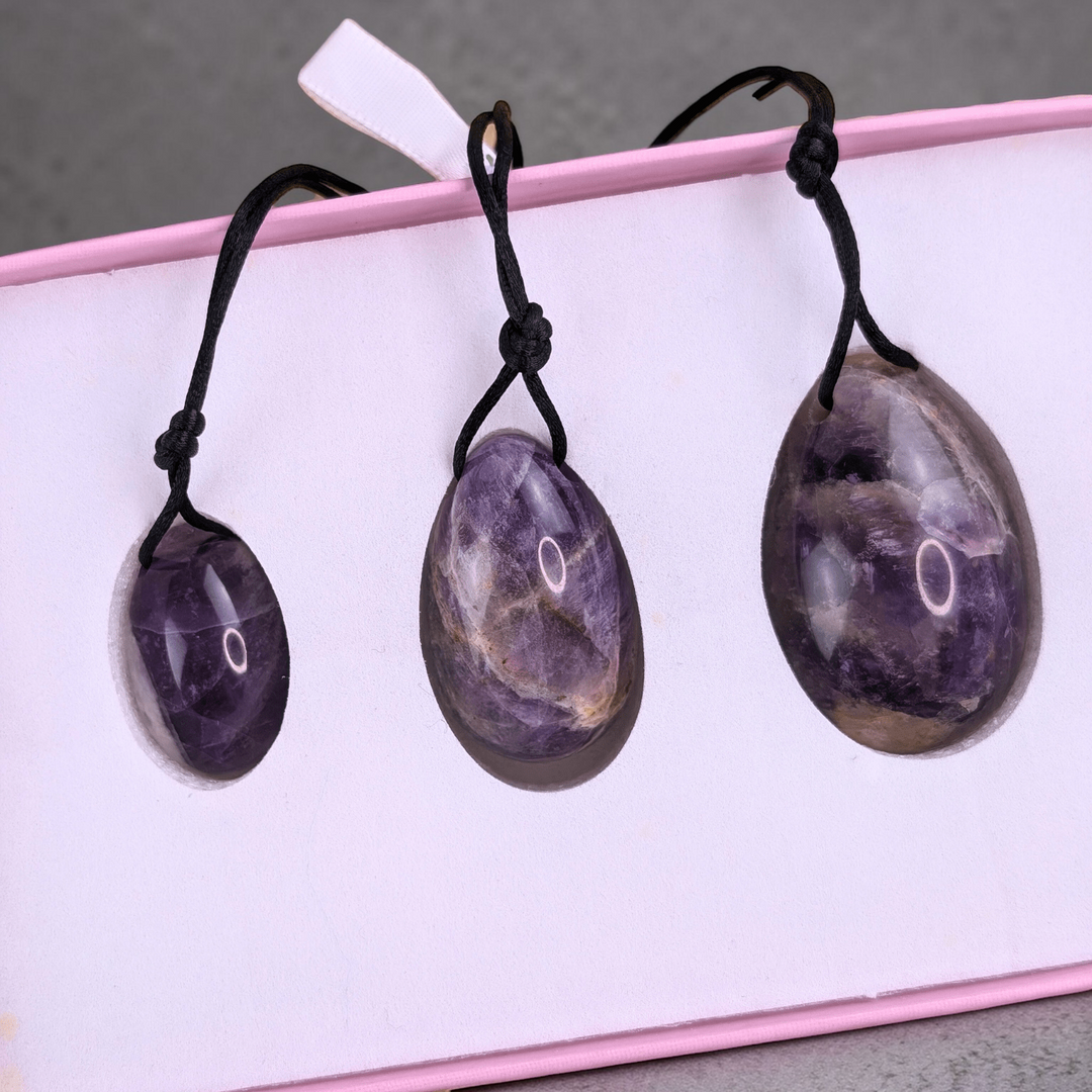 Amethyst Yoni Eggs with Strings - The set of amethyst yoni eggs with strings attached, emphasizing their design for easy use and safe removal.