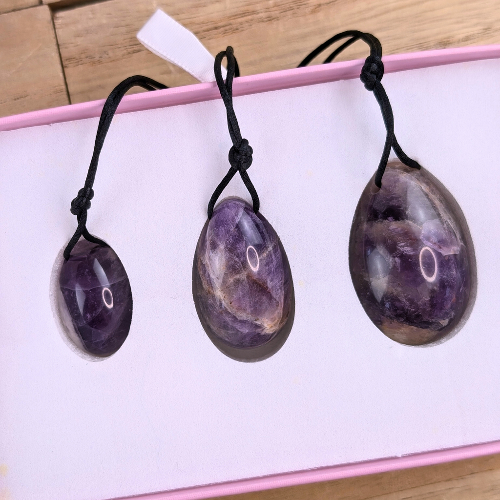 Amethyst Yoni Eggs with Strings - The set of amethyst yoni eggs with strings attached, emphasizing their design for easy use and safe removal.