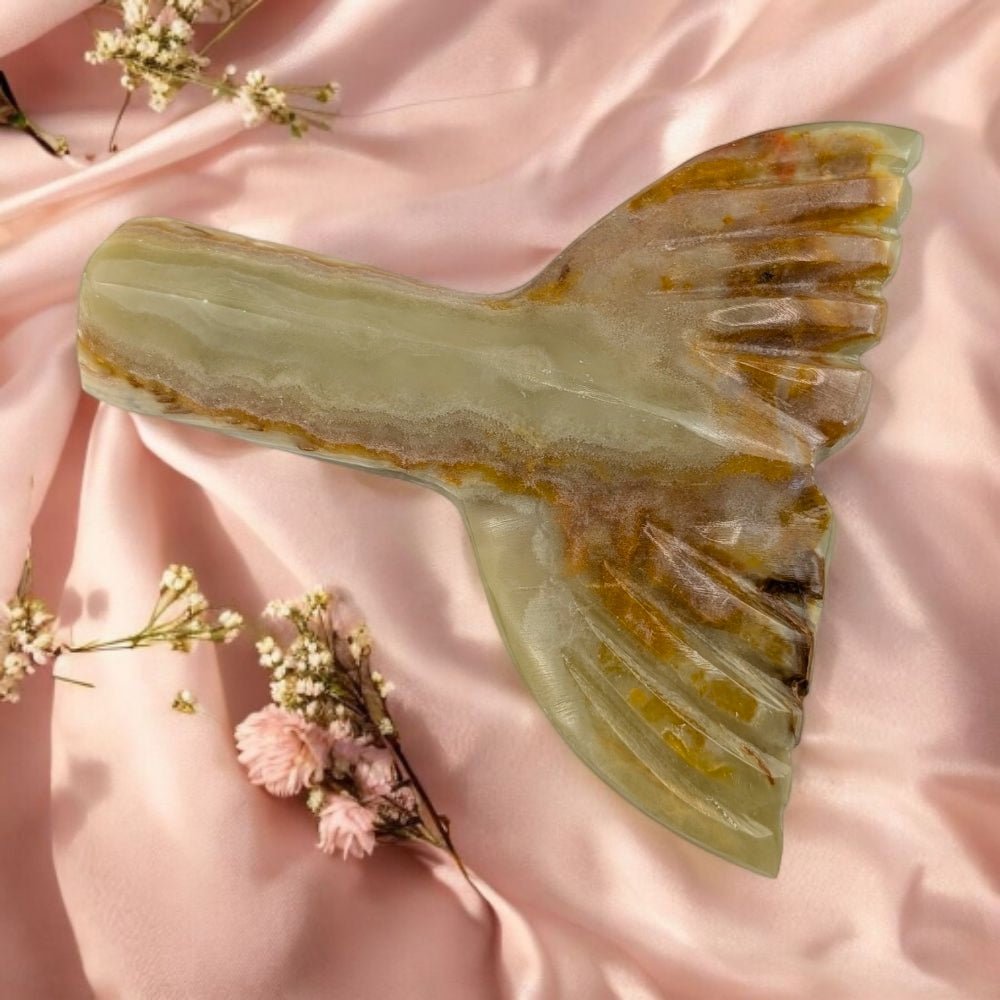 calcite stone with a mermaid-like  design on a pink fabric background