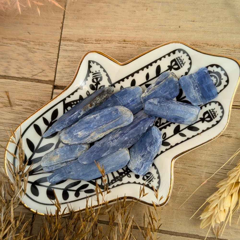 Small Blue Kyanite Blades lying flat on a wooden surface.