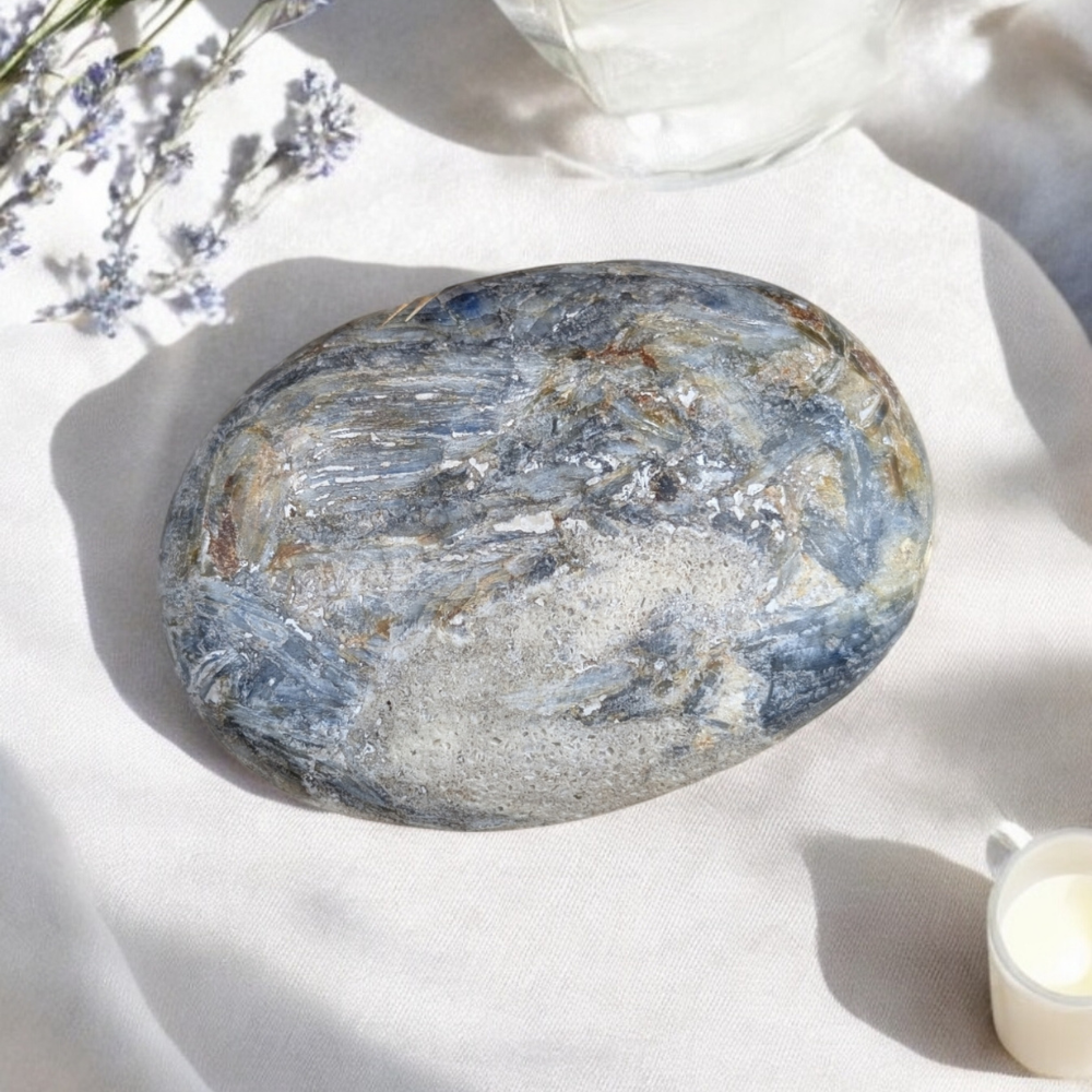 Blue Kyanite Crystal Palm Stone resting in a sacred space.