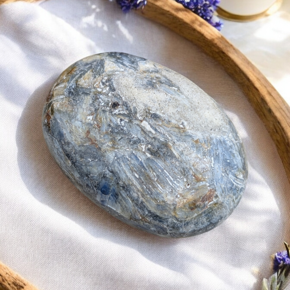 Blue Kyanite Palm Stone placed on an altar for chakra healing.
