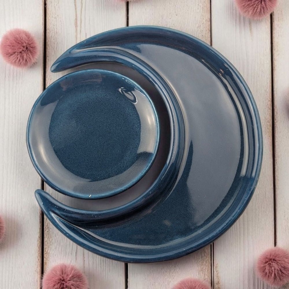 Set of blue ceramic bowls on a light wooden surface with pink decorative elements.
