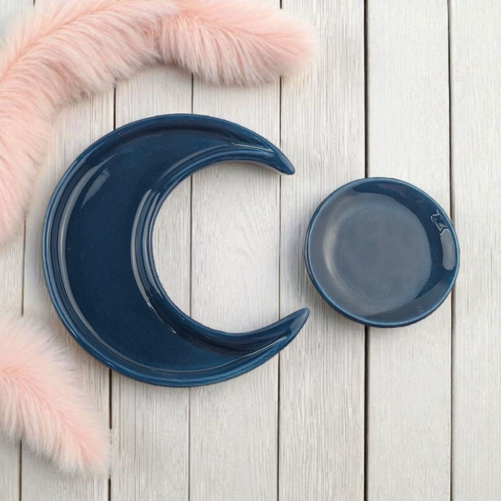 Two blue ceramic bowls, one shaped like a crescent moon, on a light wooden surface.