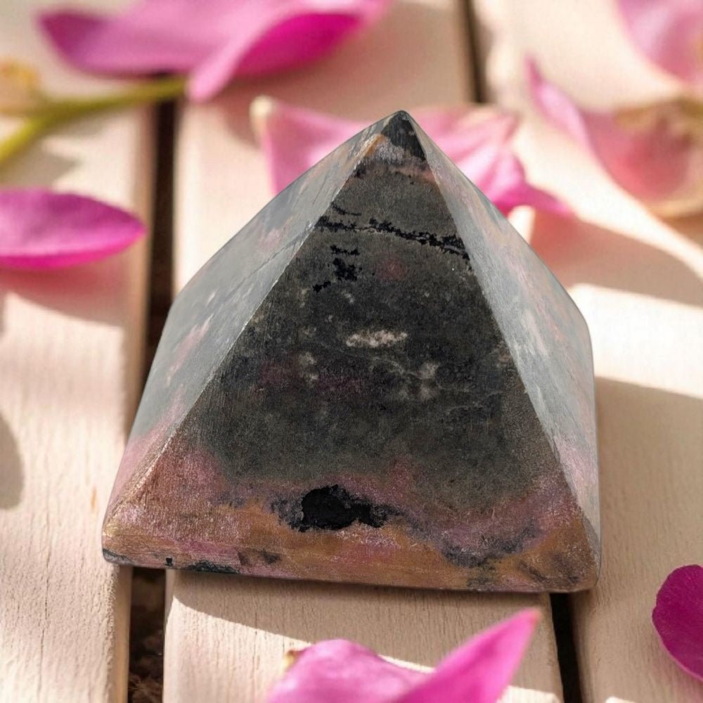 Pyramid-shaped stone with pink flowers in the background