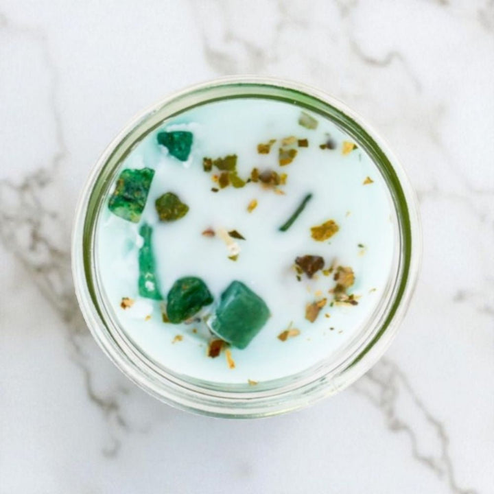 Glass jar with green dessert on a marble surface