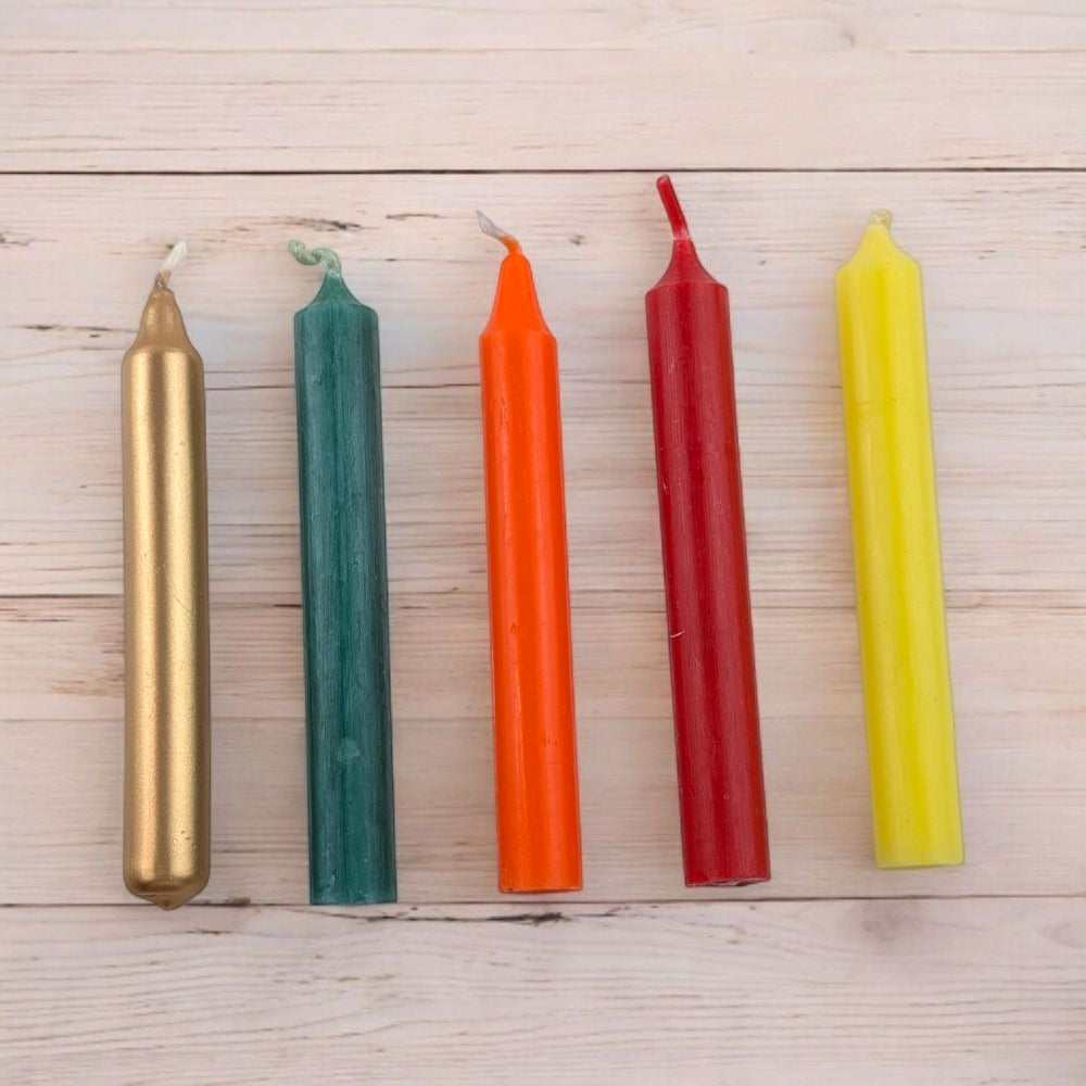 Five colorful ritual candles for steady success and humble leadership on a wooden surface