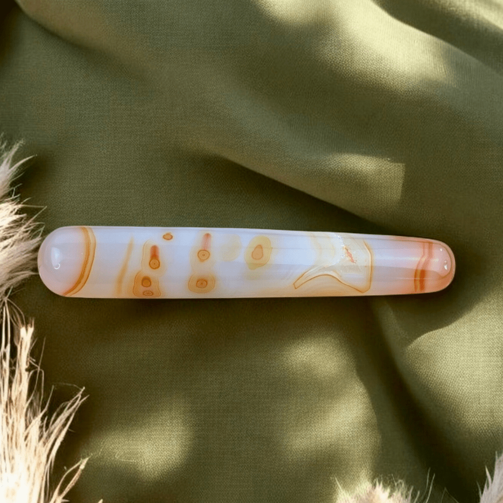 Massage wand crafted from carnelian, perfect for sacral chakra work.