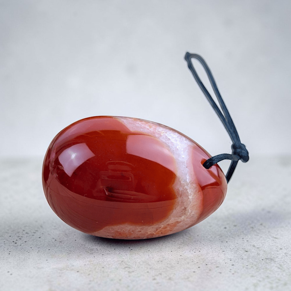 Carnelian yoni egg set displayed on soft fabric.