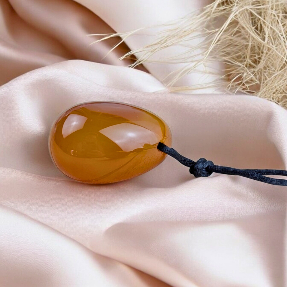 Carnelian yoni egg set displayed on soft fabric.