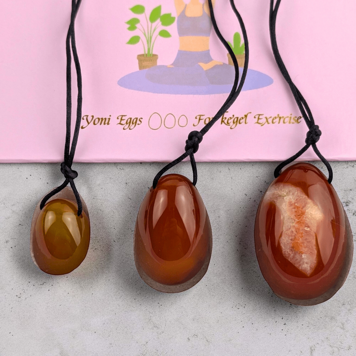 Three sizes of carnelian crystal yoni eggs.