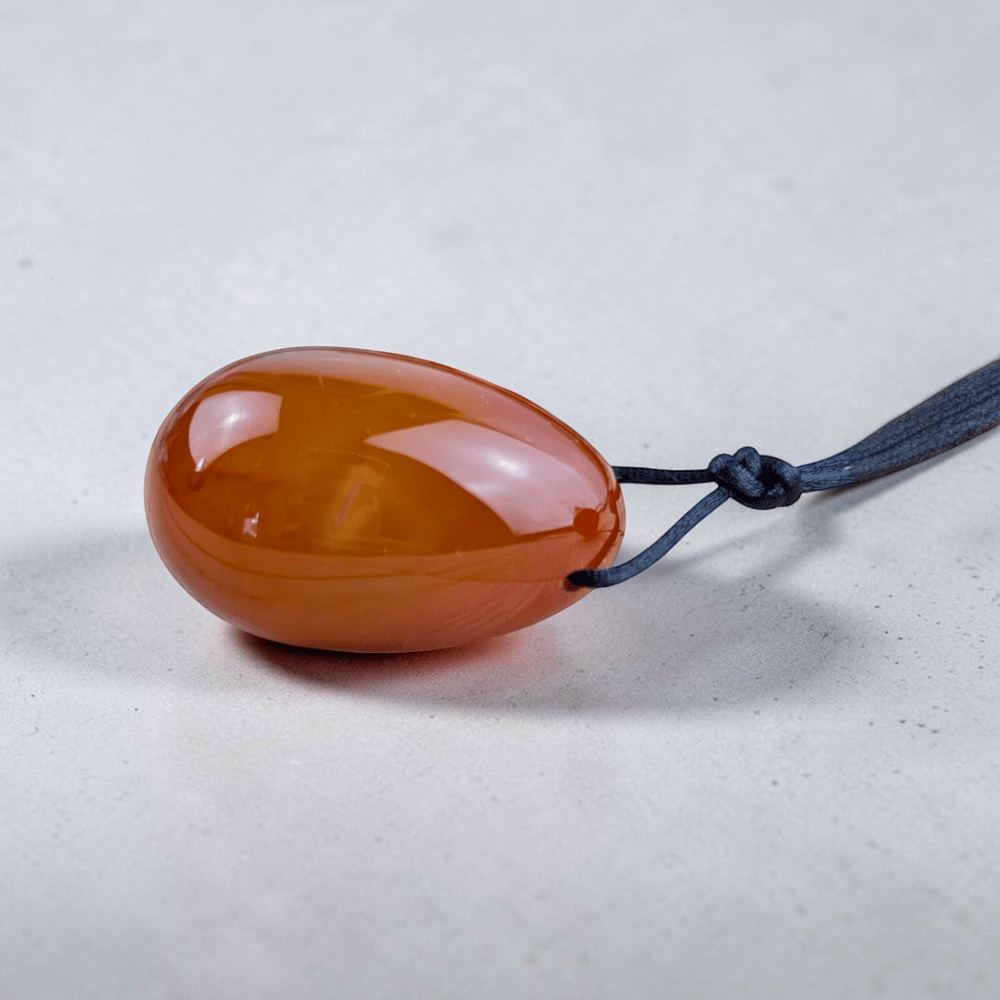 Drilled carnelian yoni eggs with removable string.