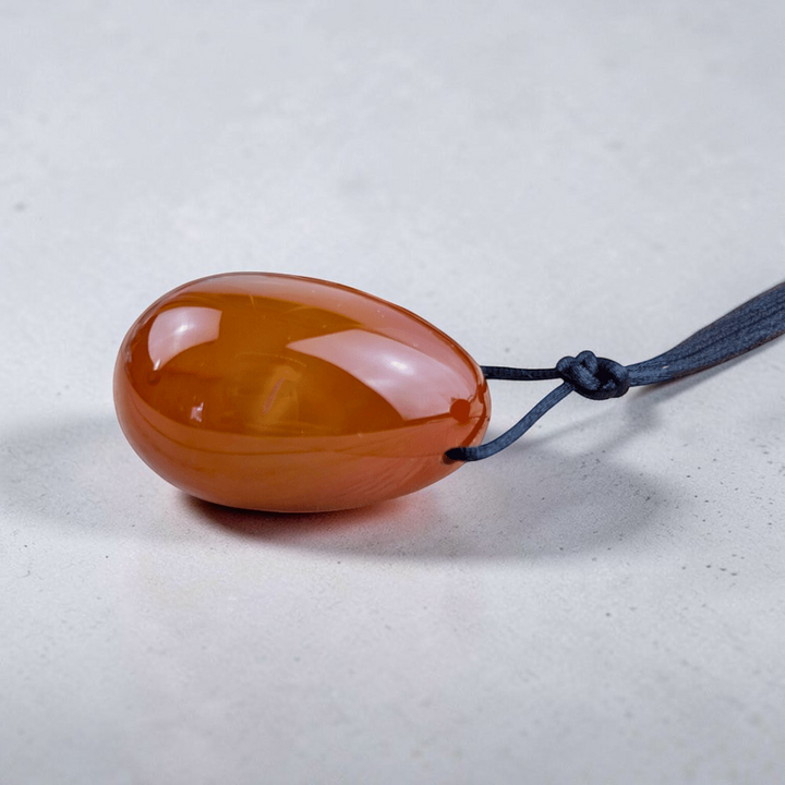 Drilled carnelian yoni eggs with removable string.