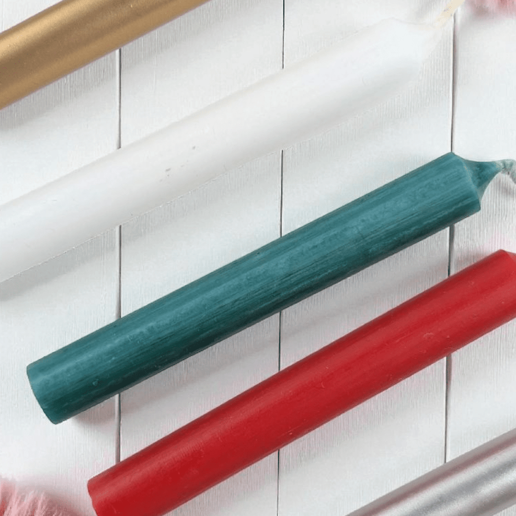 Christmas spell candles one green and one red, gold and rose gold on a white wooden surface. Available at Zen Collection Metaphysical Stores in Barrie