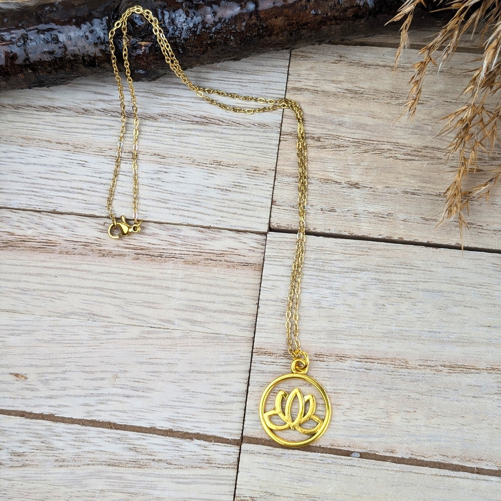 Lotus flower pendant enclosed in a golden circle on a wooden background.