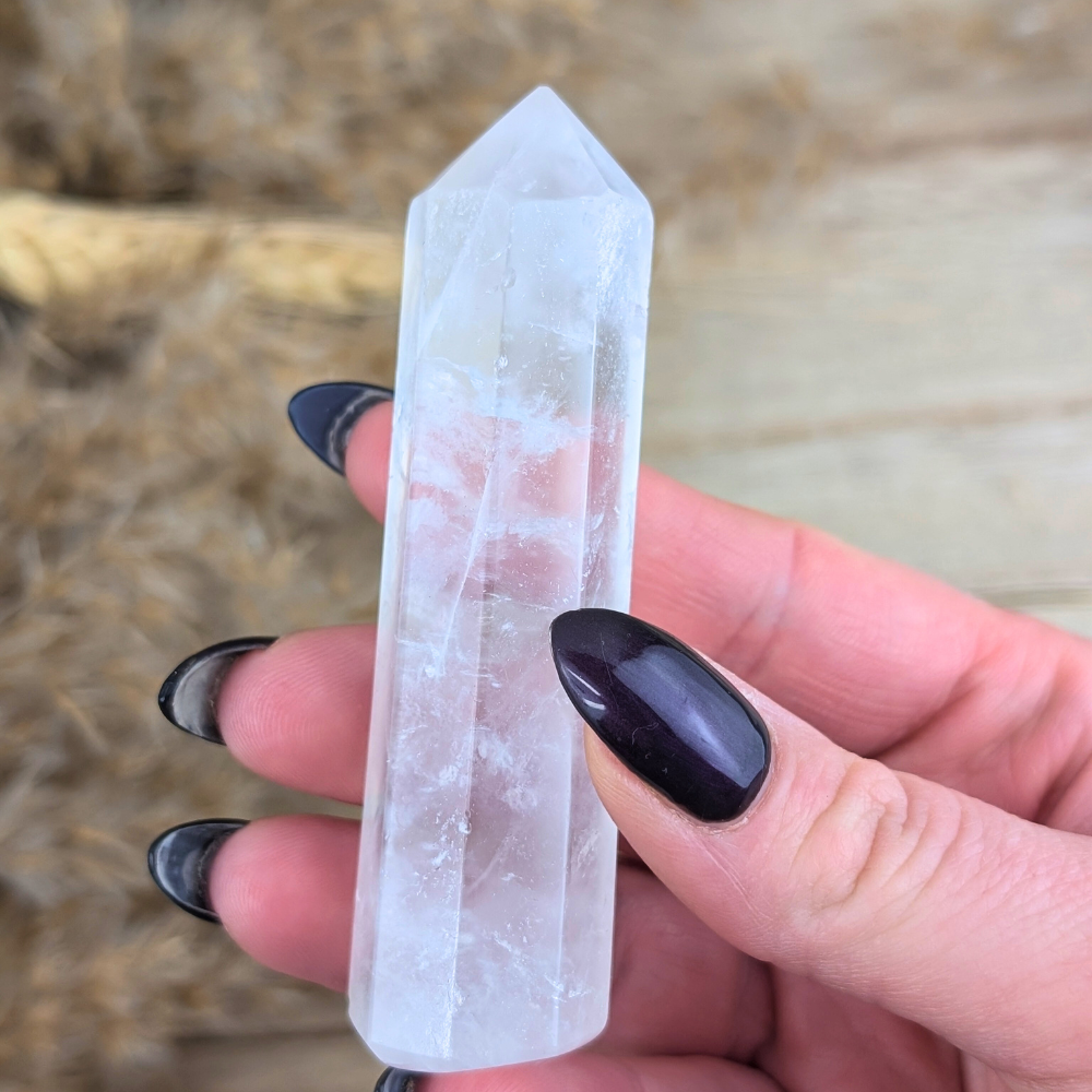 Master Healer crystal point held with black nail polish