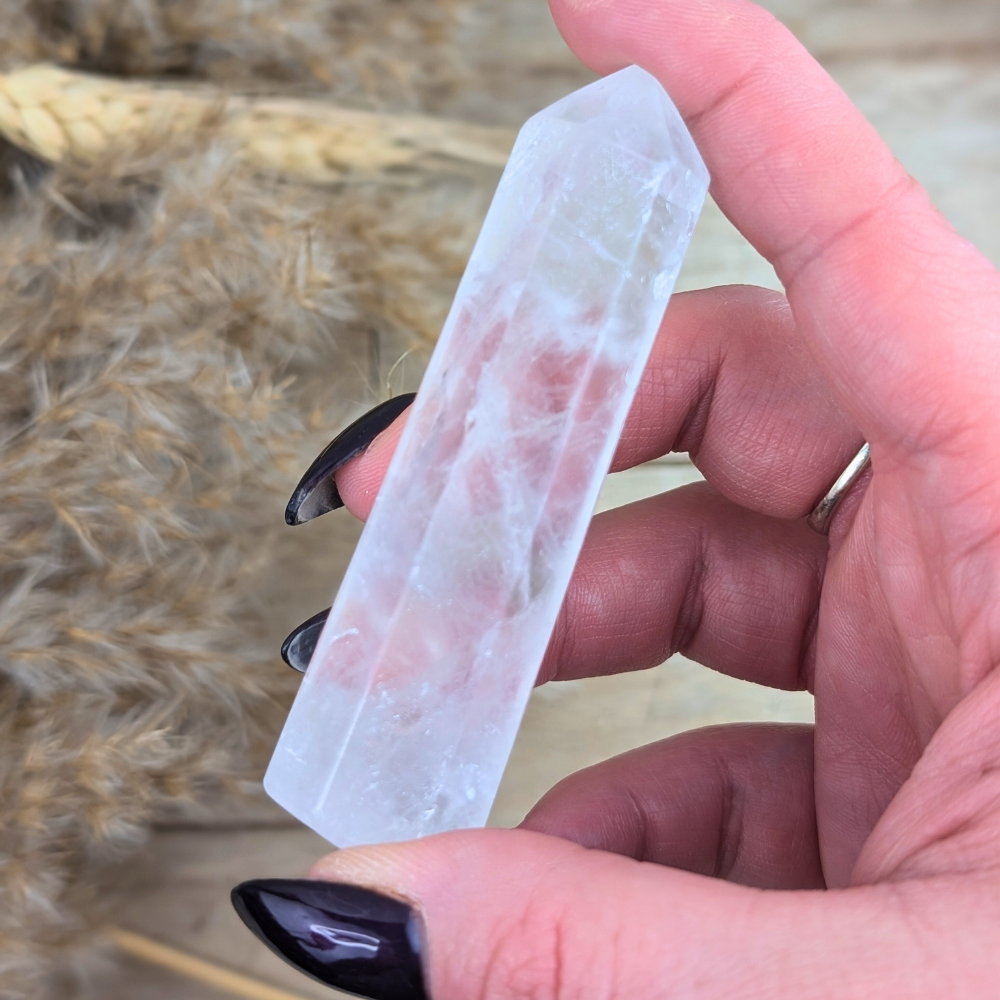 Clear Quartz Point crystal lying flat, showcasing its polished edges.