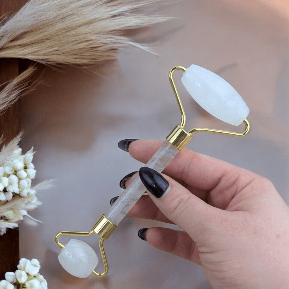 Natural clear quartz facial roller on a wooden background.