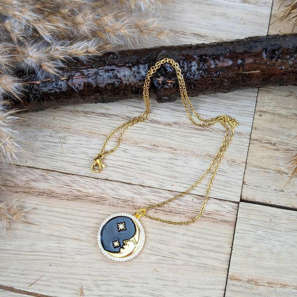 Brass crescent moon and star necklace with black enamel, symbolizing cosmic harmony