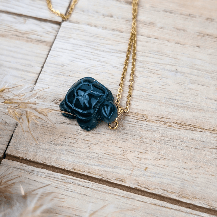 Green Agate Turtle Necklace on a wooden background.