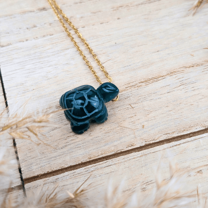 Green Agate Turtle Necklace displayed flat with a soft backdrop