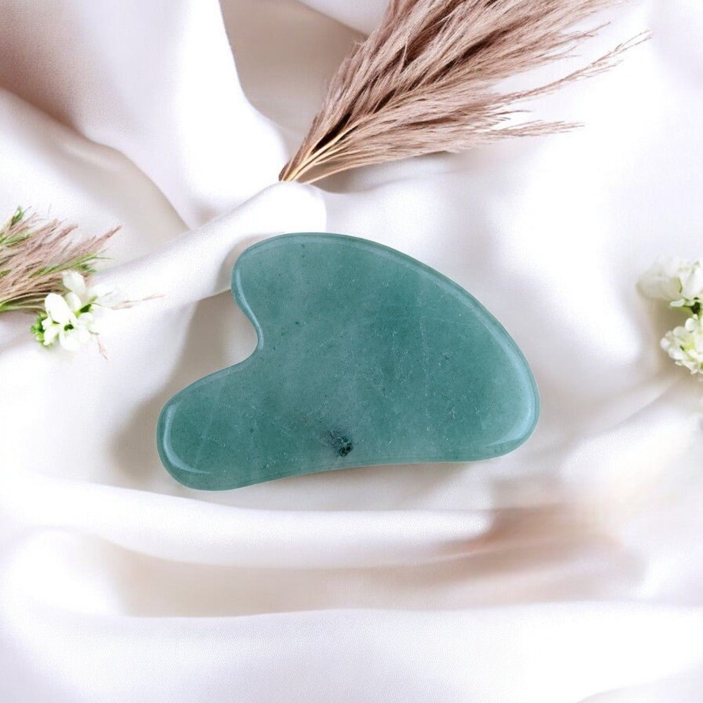 Gua sha tool in smooth green aventurine for skin care and relaxation.