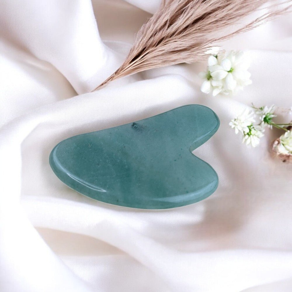 Close-up of green aventurine gua sha showcasing soft green tones.