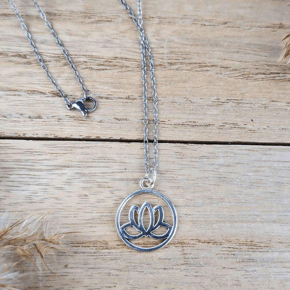 Guiding Lotus Necklace displayed on a wooden background.