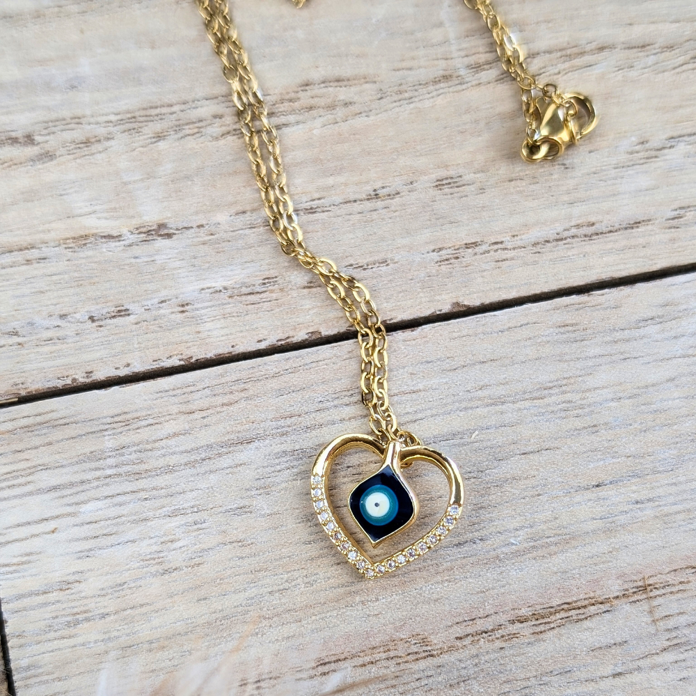 Close-up of a heart-shaped pendant featuring an embedded evil eye motif.