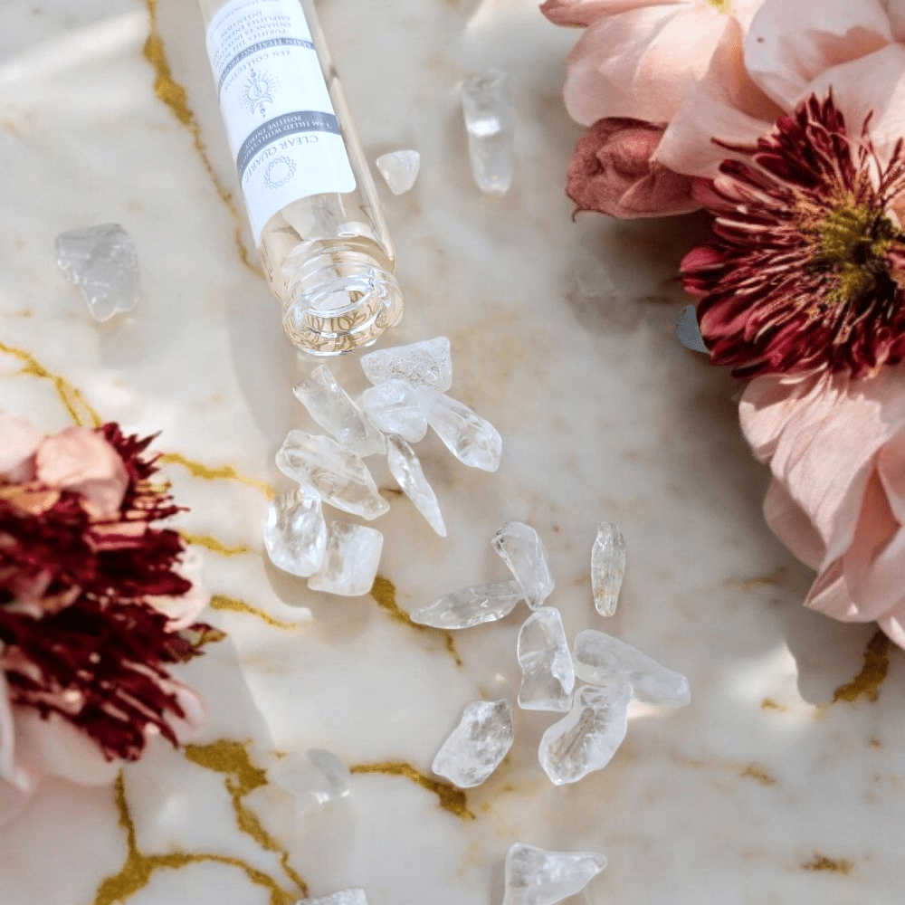 clear quartz crystals and flowers on a marble surface