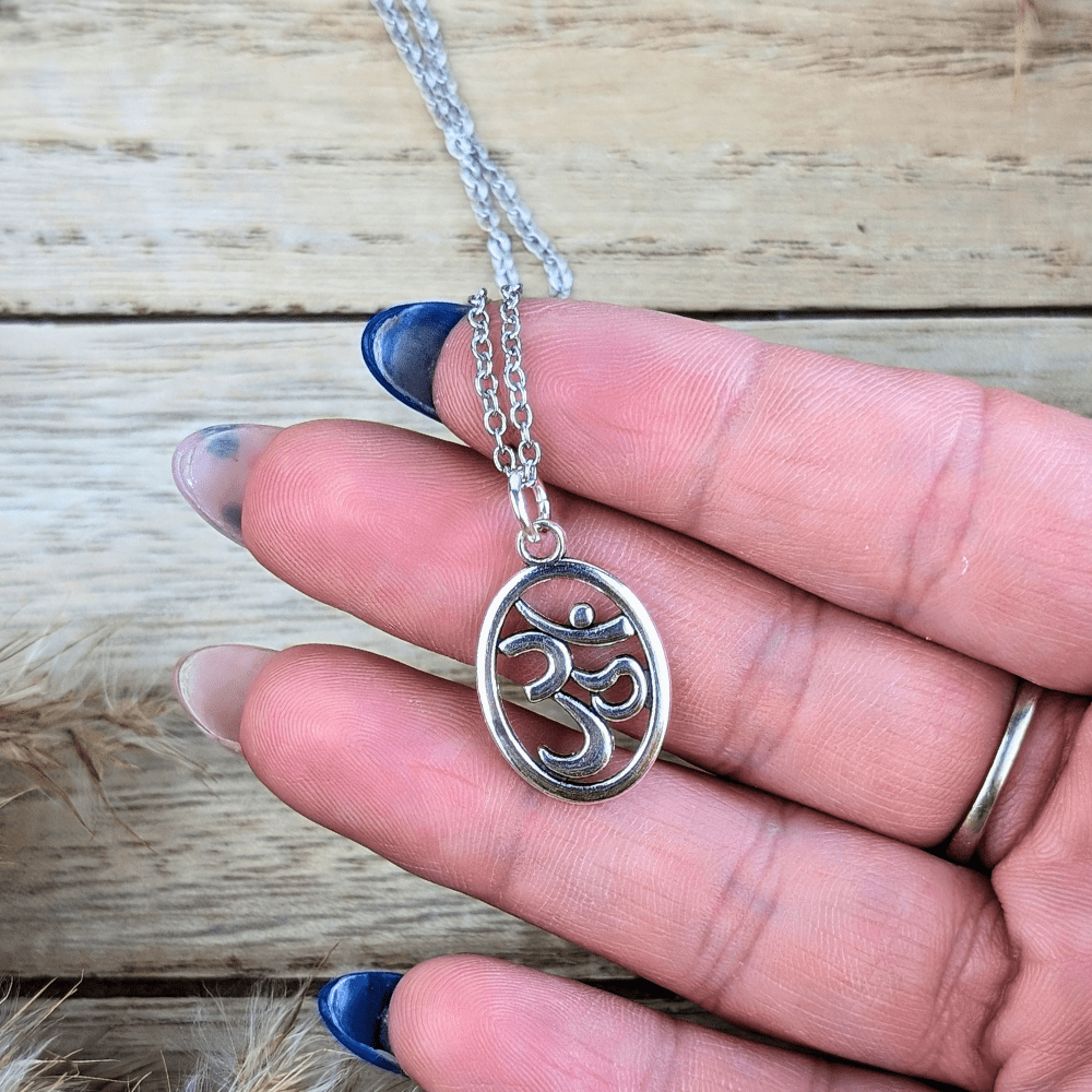 Elegant silver-tone necklace featuring a flowing oval design and Om symbol