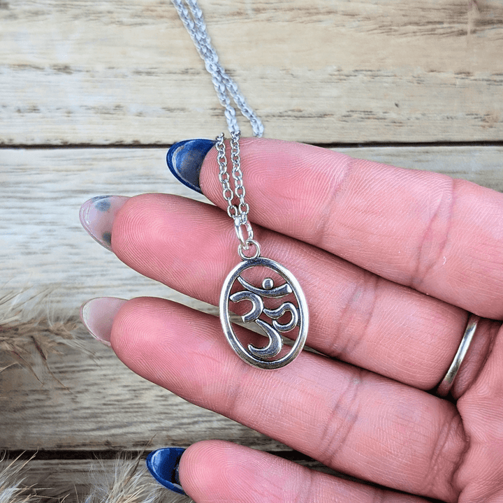 Elegant silver-tone necklace featuring a flowing oval design and Om symbol