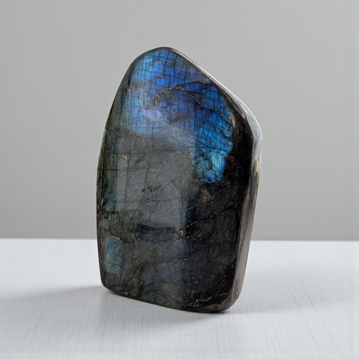 Third Eye Labradorite stone with blue and purple flash on a gray background. Shop In-store or Online Now with Zen Collection Metaphysical Store Barrie 