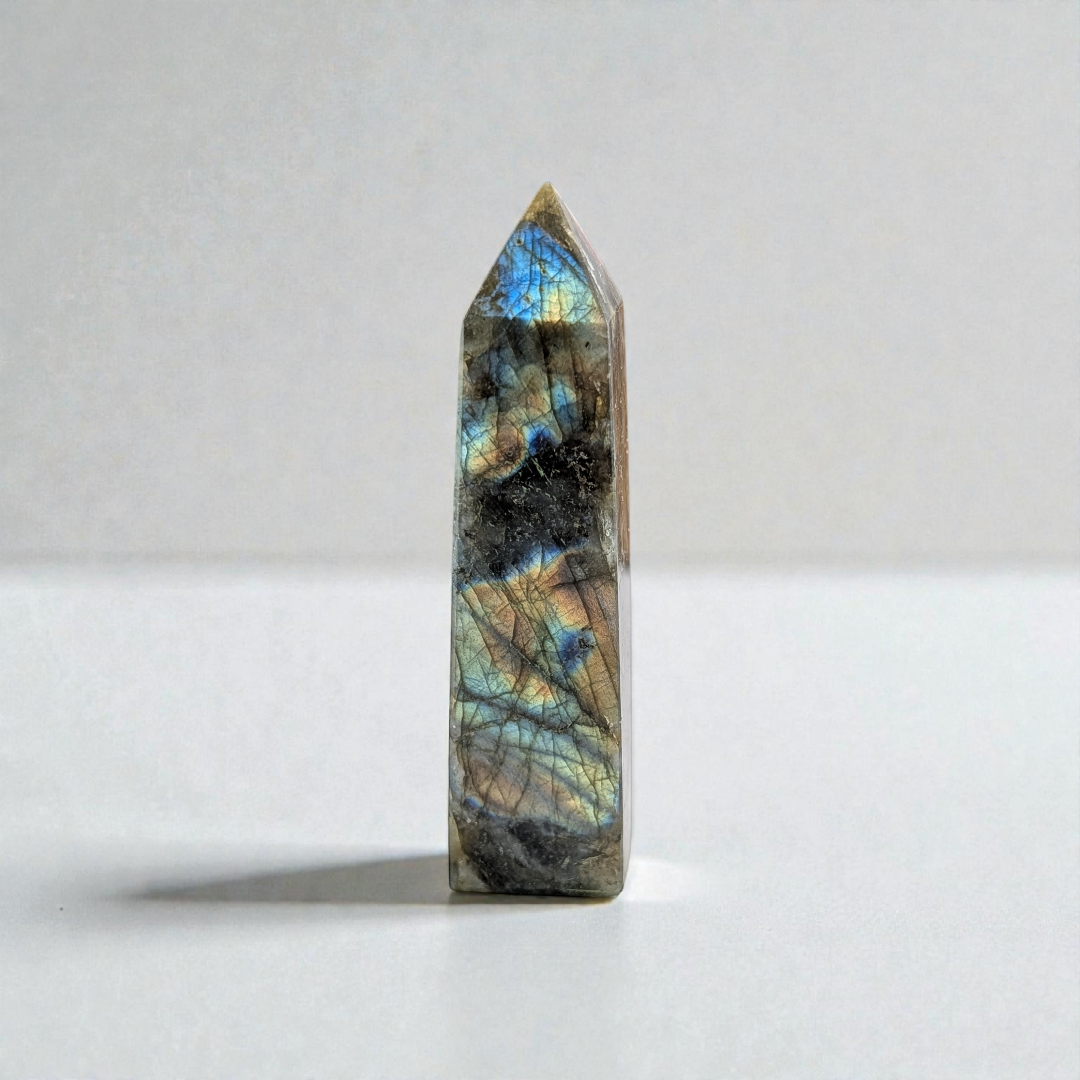 Hand holding Labradorite Tower for spiritual growth and protection.