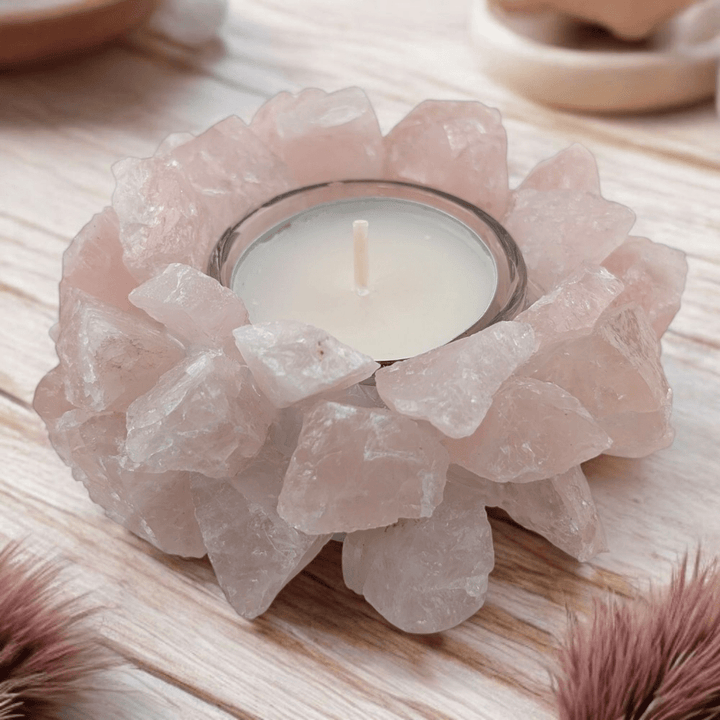 Candle holder made of rose quartz crystals on a wooden surface