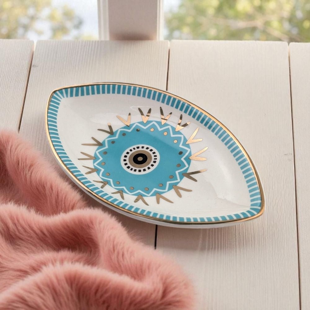 Decorative plate with blue and gold design on a light wooden surface