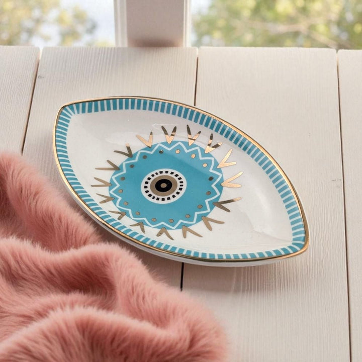 Decorative plate with blue and gold design on a light wooden surface