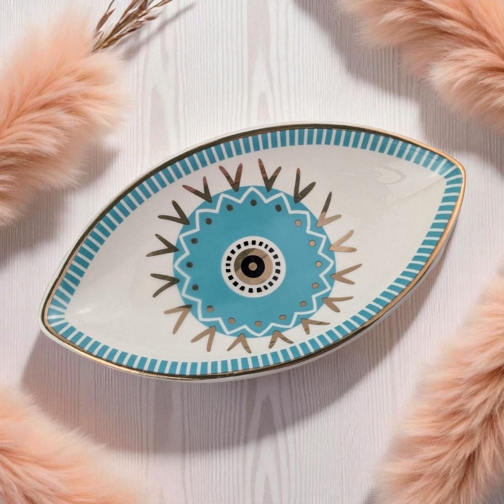 Decorative plate with eye design on a light wooden surface with pink fur accents