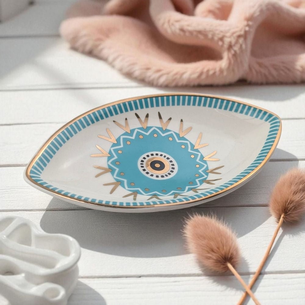 Decorative plate with blue floral design on a light wooden surface with decorative elements.