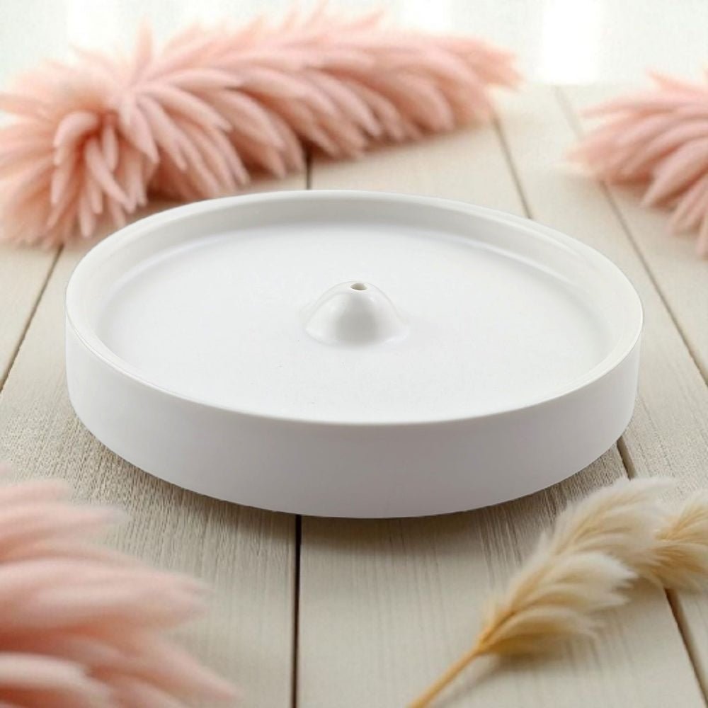 White ceramic dish on a light wooden surface with decorative elements.
