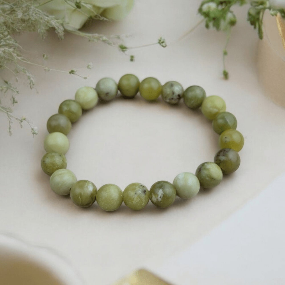 Peridot Bracelet displayed on a wooden surface with soft lighting.